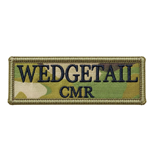 A rectangular embroidered patch with a camouflage pattern in shades of green and tan, featuring the word ’wedgetail’ in bold black lettering above ’cmr,’ bordered by a stitched olive-green edge