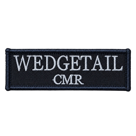 Black embroidered patch with white thread lettering reading ’wedgetail cmr’